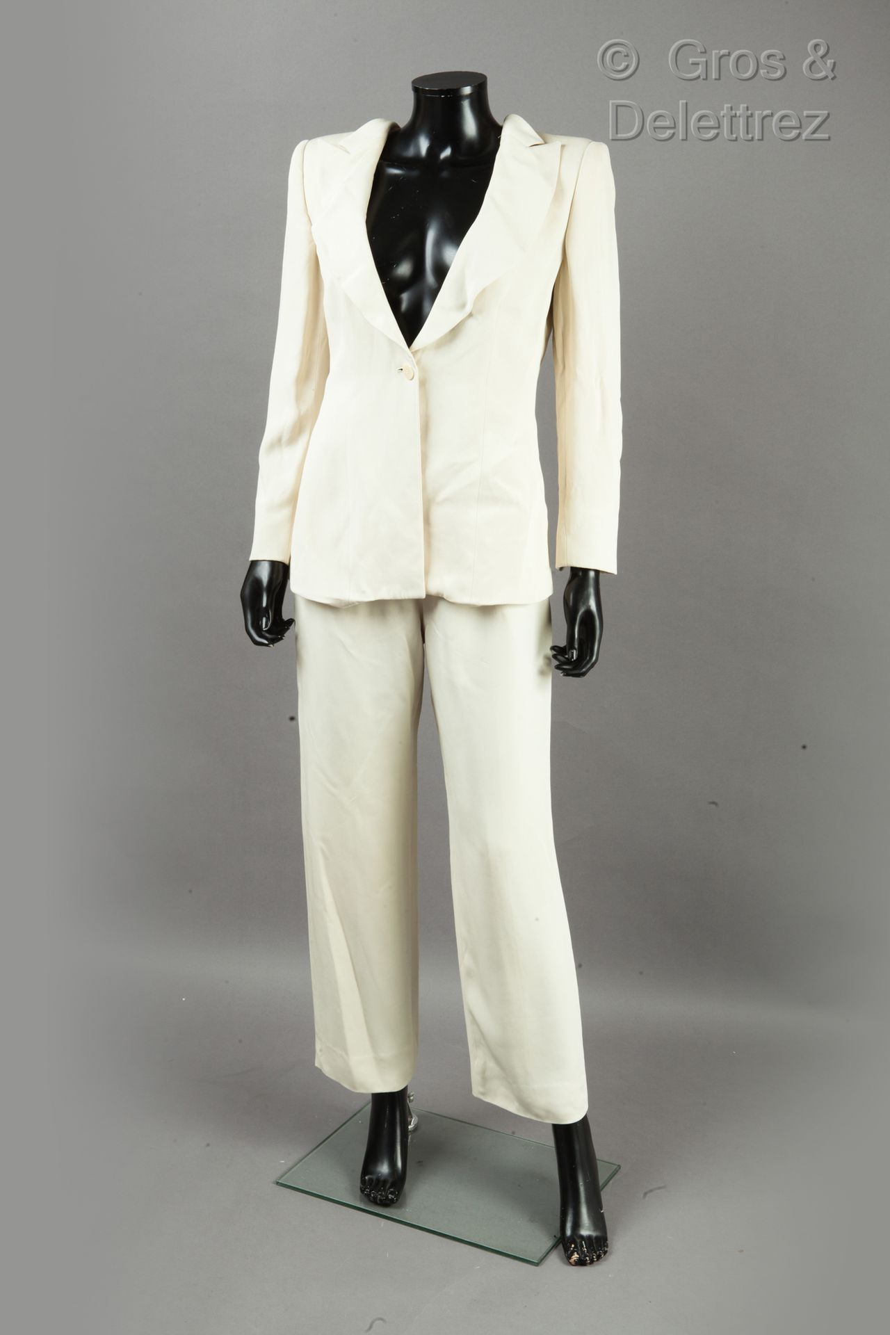 Giorgio ARMANI 西装采用生态蓝真丝绉绸，由外套、荷叶边披肩领、单扣门襟、长袖、后开衩和长裤组成。黑爪子，白图形。T.42.