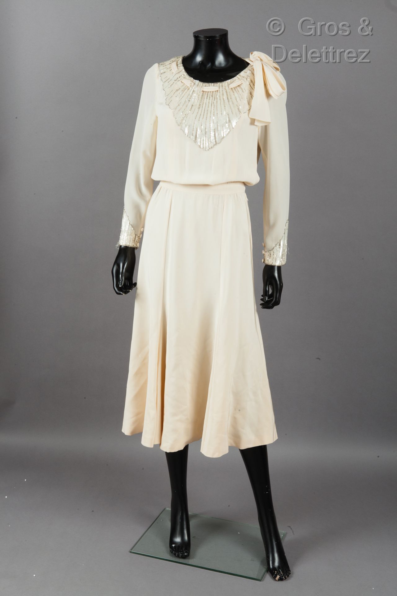CHANEL Boutique par Karl LAGERFELD 1984年春夏系列

象牙色真丝绉绸长裙，绣有珍珠和亮片，圆领口以系带突出，长袖。白色标签&hellip;