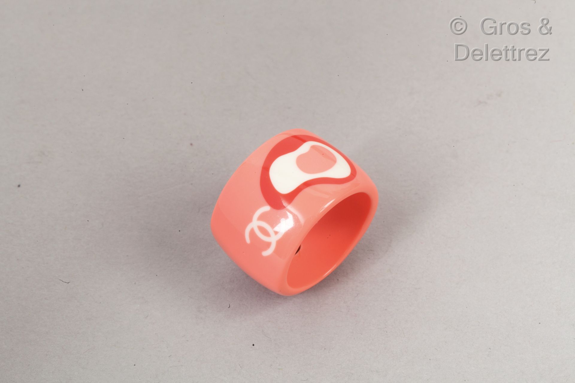 CHANEL par Karl LAGERFELD 2003年春夏高级成衣系列

粉红色的树脂戒指，装饰有该品牌的标志，并以一个图案作为底纹。盘上有签名。