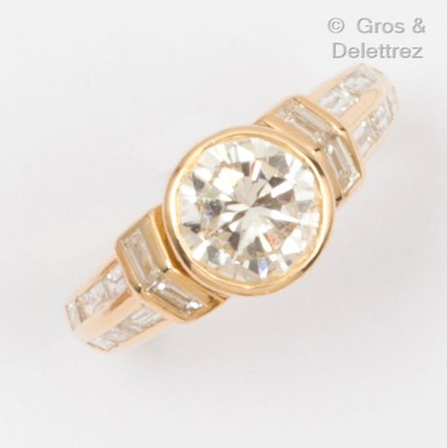 Null 黃金 "單鑽 "戒指，鑲有一顆圓形切割鑽石和長方形鑽石。

主钻石的重量：1.54克拉。

颜色：G。

清晰度：VVS1。

它带有巴黎CCI的证书&hellip;