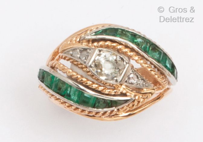 Null 黄金戒指上装饰着扭曲的金线，在两行校准的祖母绿之间镶嵌着一颗老式切割钻石。手指大小：53。毛重：7.7克。
