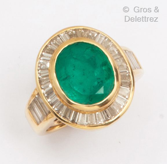 Null 一枚大型黄金戒指，在一圈长方形钻石中镶嵌了一颗椭圆形刻面绿宝石。手指大小：50。毛重：10克。