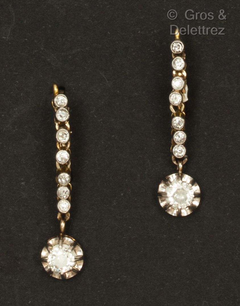 Null 一对黄金和白金 "耳环"，镶嵌着一排明亮式切割的钻石，托着一颗大钻石。卧具扣。长度：2.5厘米。毛重：4.6克。