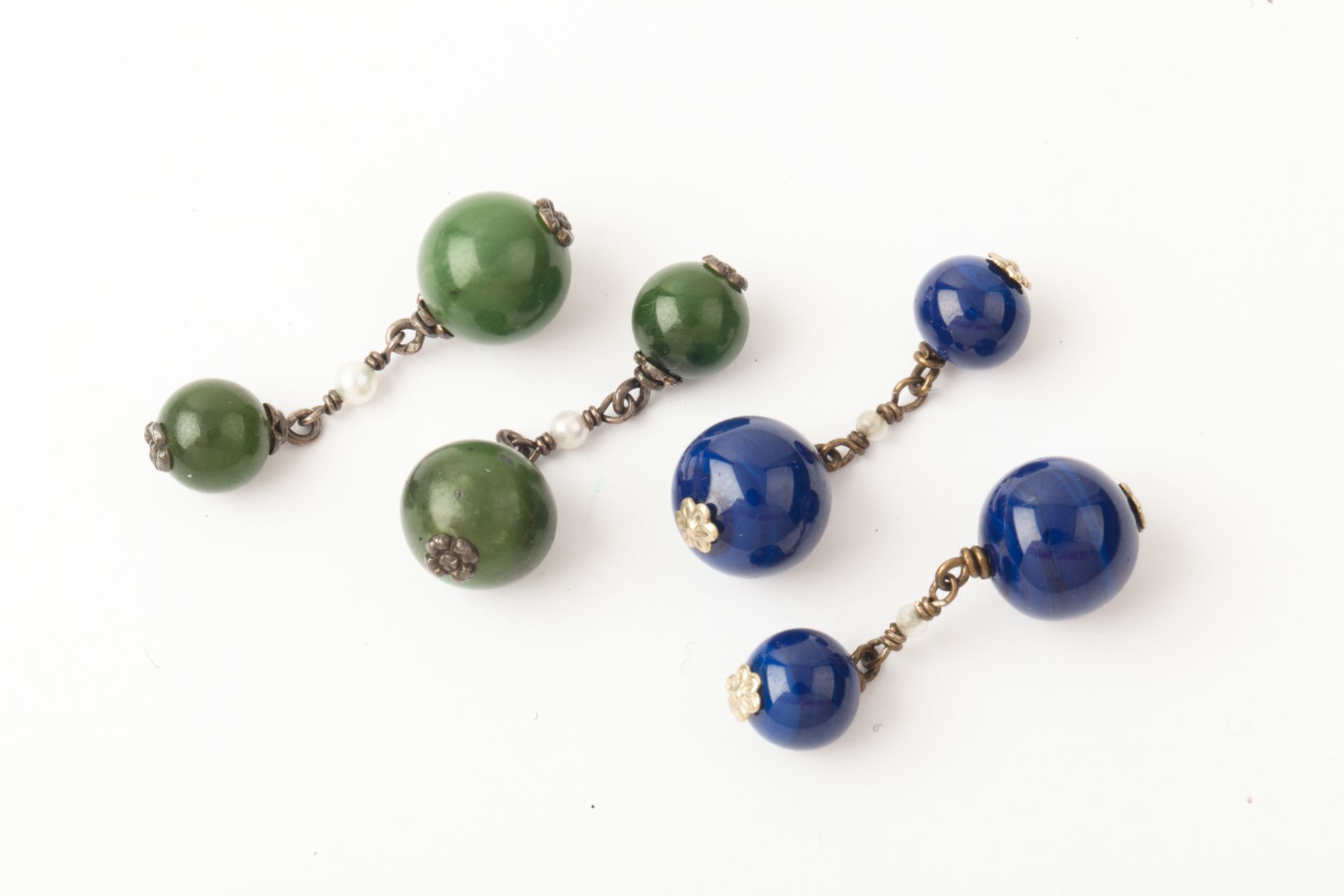 Null 本拍品由两对金属袖扣组成；其中一对用砂金石和种子珠装饰，另一对用蓝色珠子装饰。