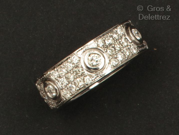 CARTIER "爱"- 白金结婚戒指，在小钻石的铺垫下镶嵌了几颗明亮式切割的钻石。有签名和编号的。手指大小：54。毛重：12.1克。