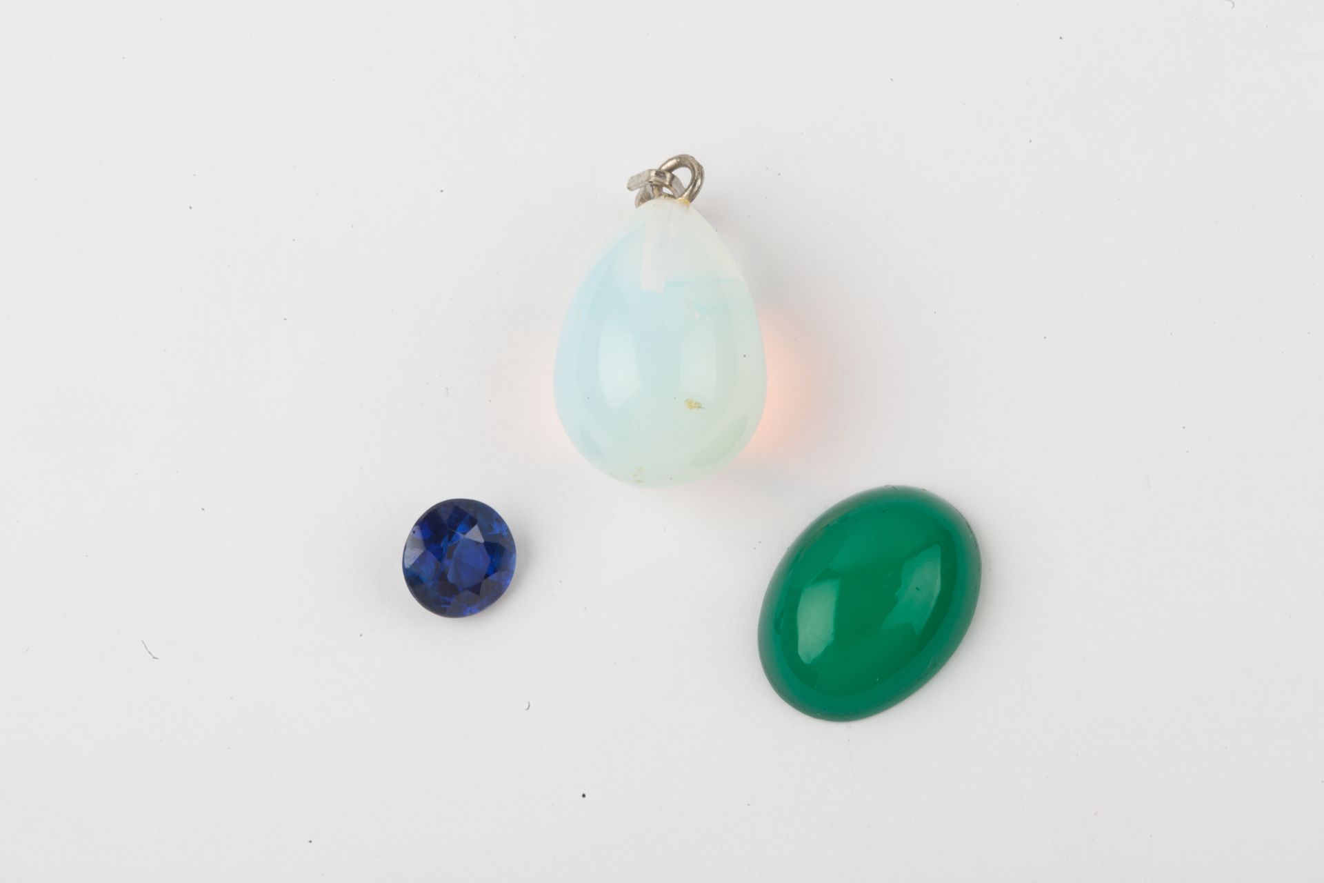 Null 纸上石头拍品，包括一块蓝色石头，一个蛋白石吊坠，和一个凸圆形绿玉石。