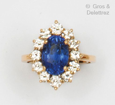 Null 黄金 "Marguerite "戒指，在明亮式切割钻石中镶嵌一颗椭圆蓝宝石。 	

蓝宝石的重量：5克拉。

手指大小：55。毛重：8.4克。(带镶嵌&hellip;