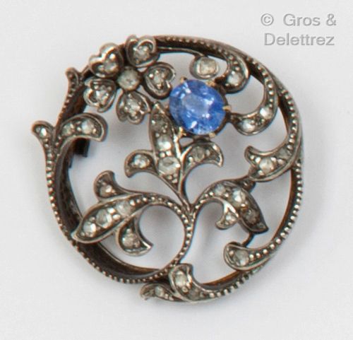 Null 圆形镂空银质胸针，上面镶嵌着玫瑰式切割钻石和一颗椭圆形蓝宝石。直径：2.8厘米。毛重：7.5克。