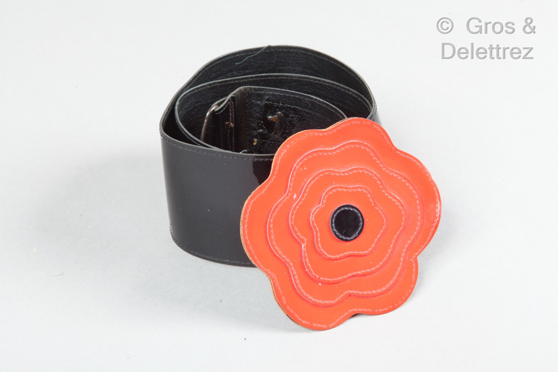 Yves SAINT LAURENT Rive Gauche 标志性的70毫米黑色乙烯基 "罂粟花 "皮带，带红色扣子。签名。长度：81厘米。