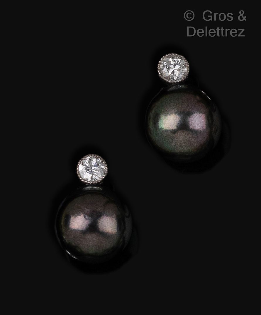 Null 一对白金耳环，每只耳环上都镶嵌着一颗灰色的大溪地珍珠和一颗明亮式切割的钻石，并以珍珠镶嵌。珍珠的直径：11毫米。毛重：6.5克。