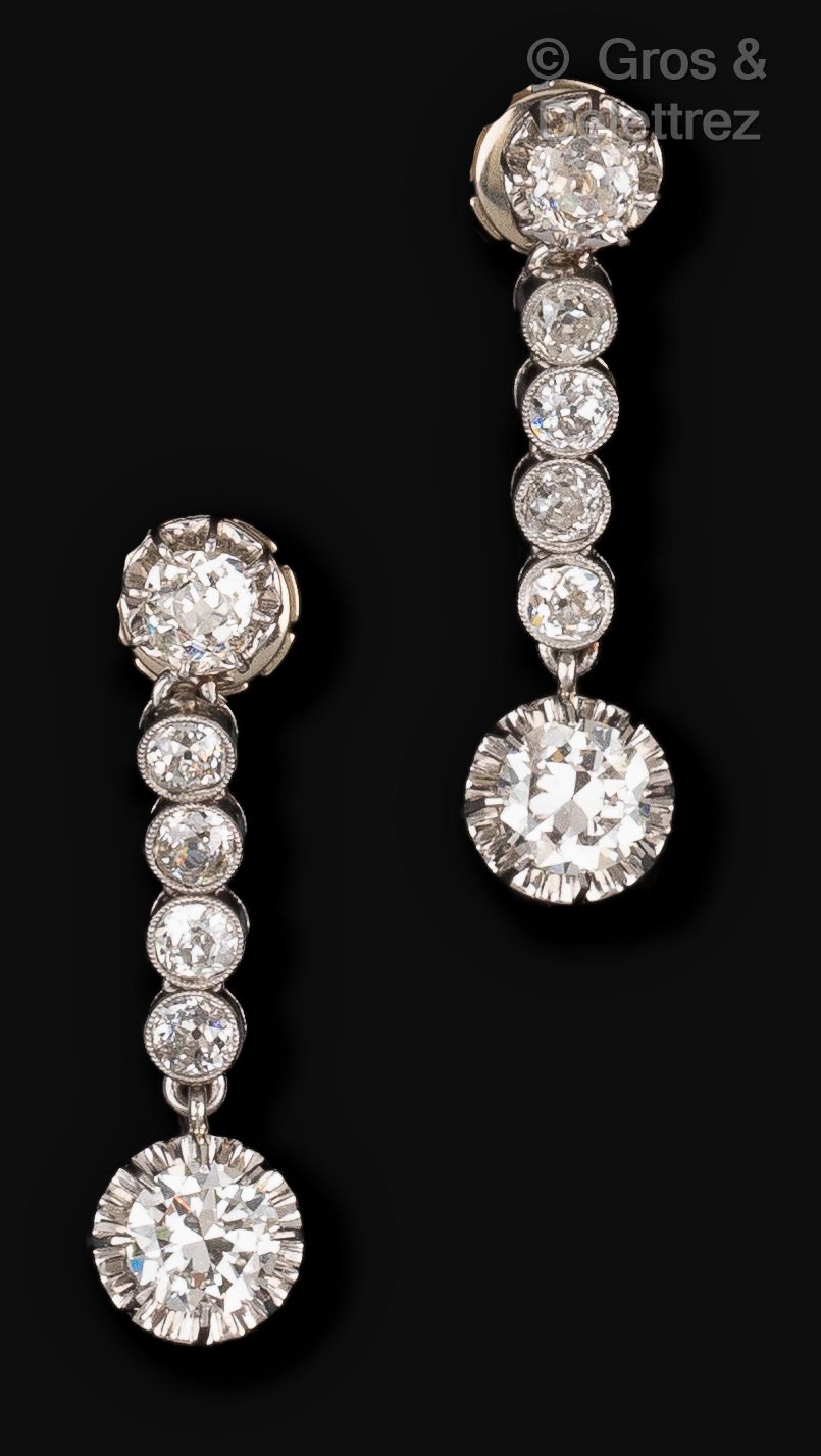 Null 一对白金耳环，镶有明亮式切割钻石，顶部有一排老式切割钻石。 	

两颗主钻的重量：每颗约1克拉。长度：3.5厘米。毛重：9.6克。