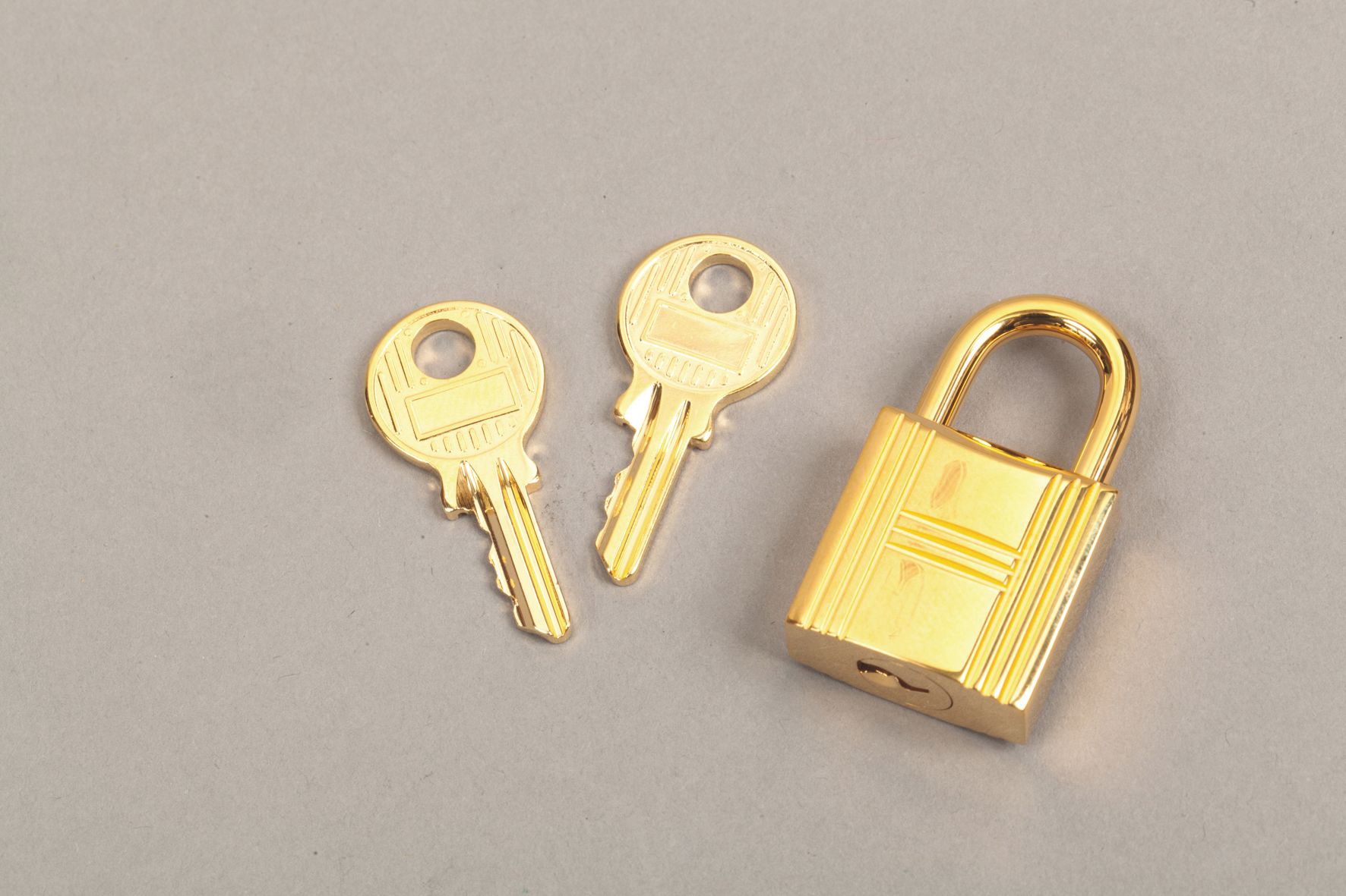 Null *HERMES Paris - Vorhängeschloss aus vergoldetem Metall, zwei Schlüssel.