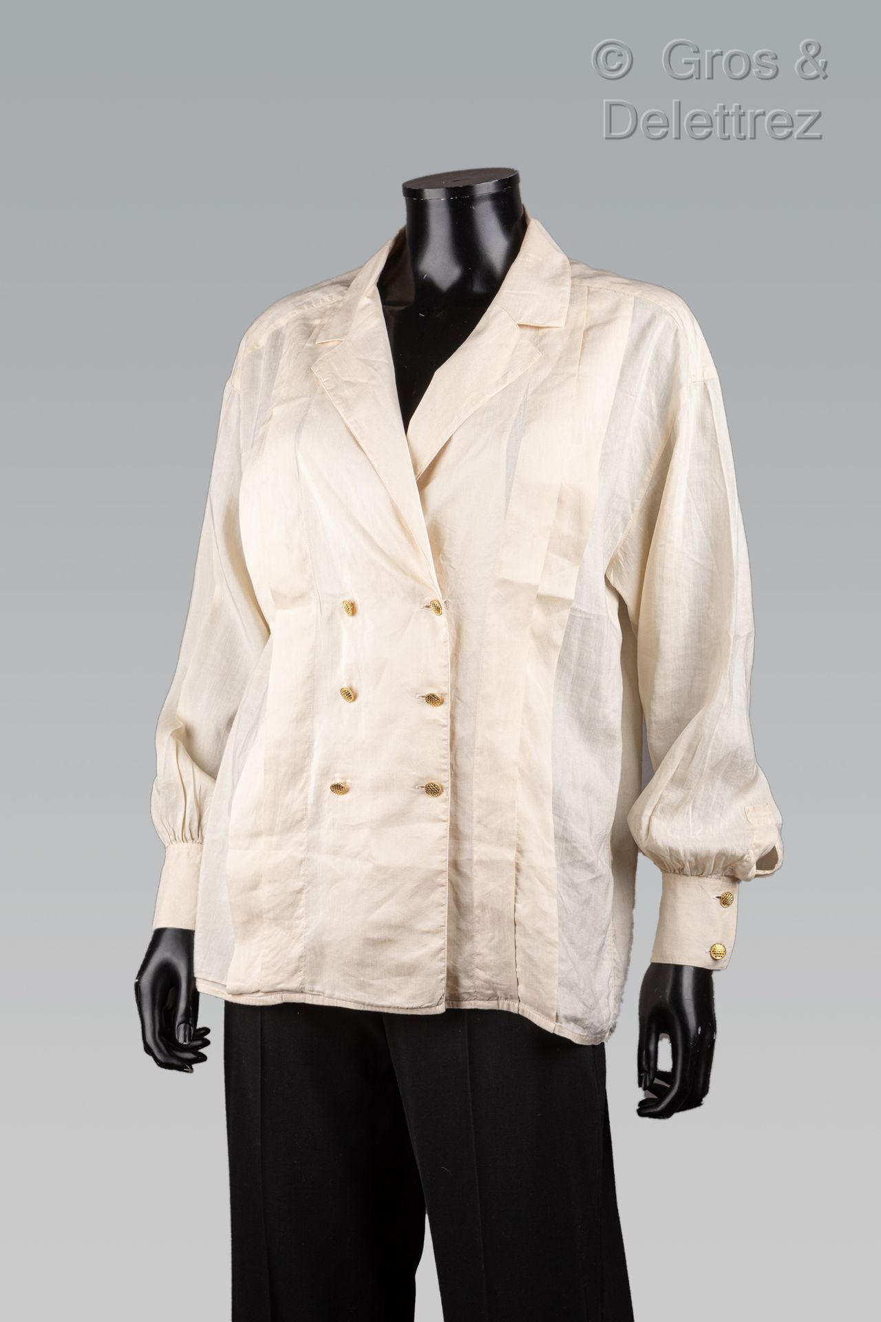 Null 香奈儿

米白色亚麻布衬衫，缺口领，双排扣，前面有平褶装饰，长袖。白色标签，黑色图案。