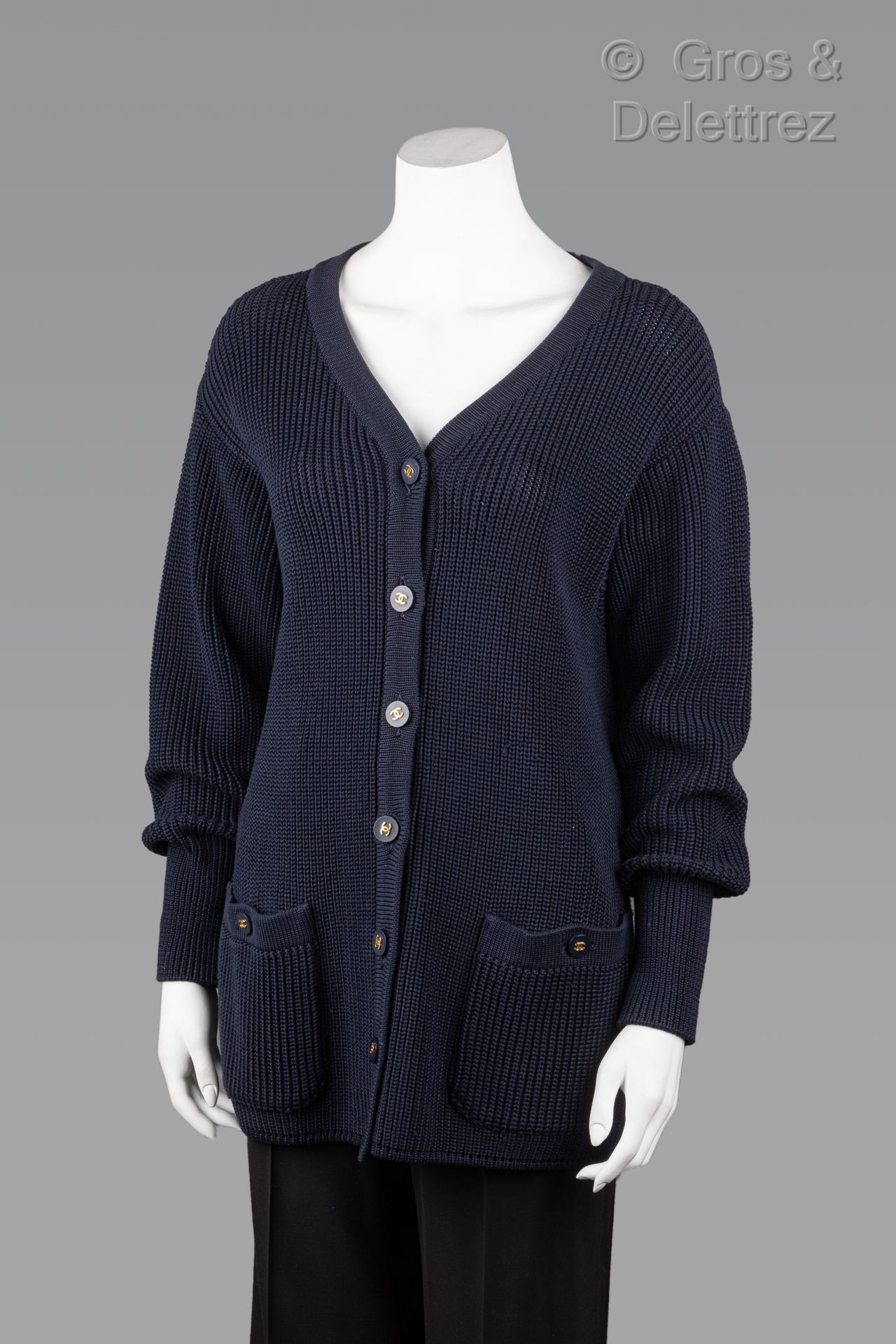 Null 卡尔-拉格斐的香奈儿专卖店

1996年巡航系列

藏青色针织长开衫，V领，单排扣，两个贴袋，长袖。黑色标签，白色图案。S 36 (拉线)