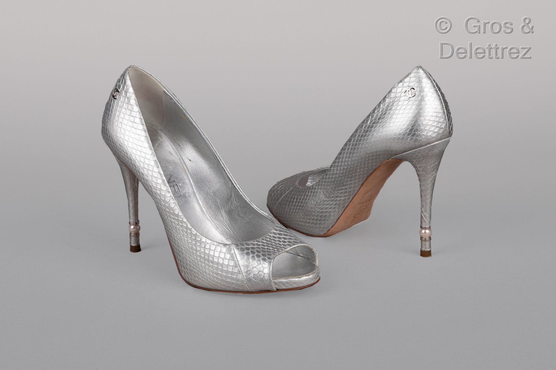 Null 卡尔-拉格斐的香奈儿

2016年春季/夏季成衣系列

一双银色光泽的蟒蛇皮鞋，110毫米的有盖鞋跟，穿插着一颗仿白珍珠，皮革鞋底。T.38.状况非常&hellip;