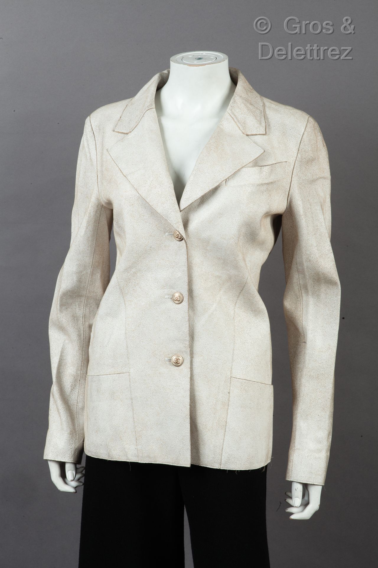 Null 卡尔-拉格斐的香奈儿

2003年春夏高级成衣系列

陈年白色小羊皮西装外套，缺口披肩领，单排扣，胸袋，两个贴袋，长袖。白色标签，黑色图案。T.40.
