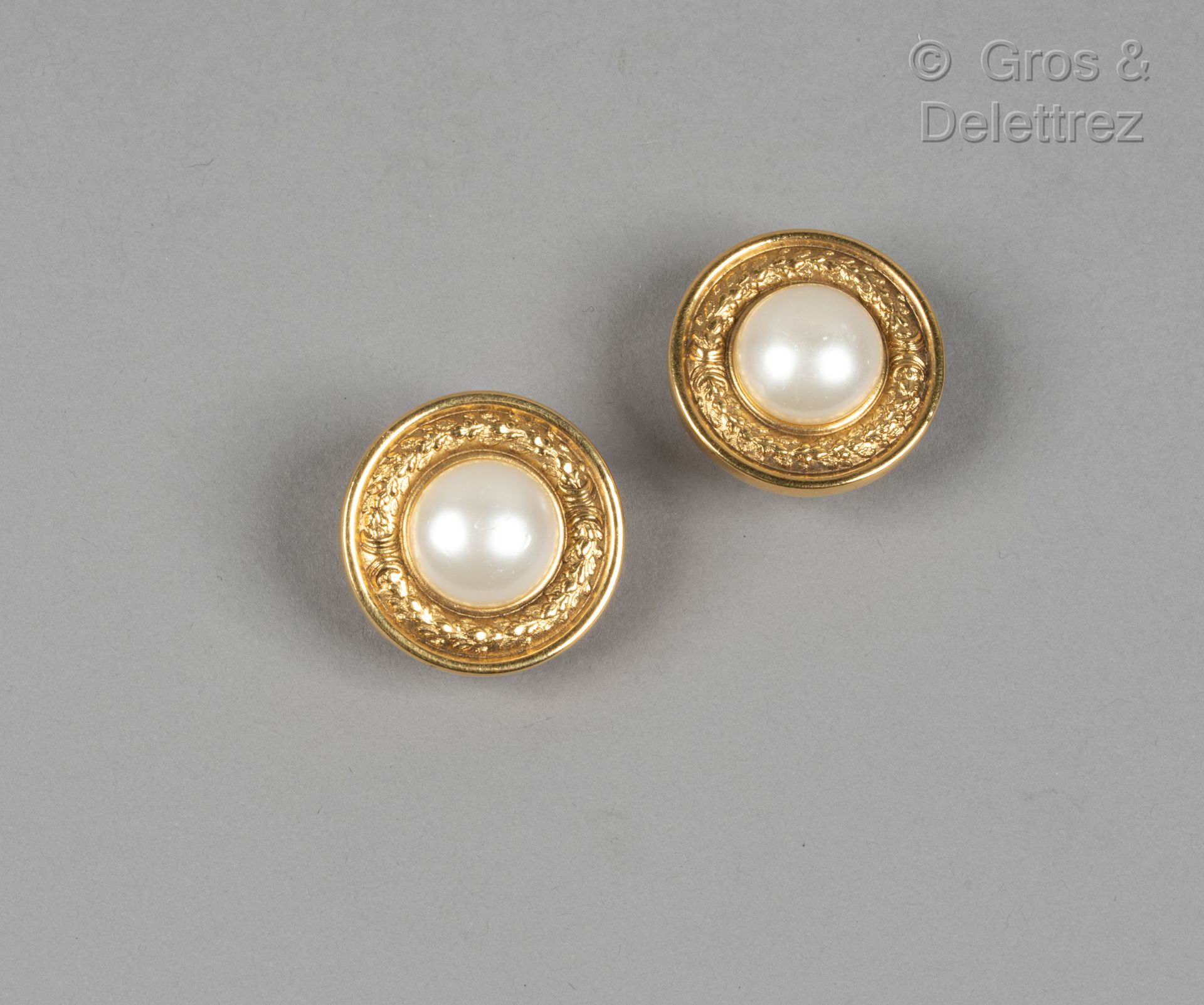 Null 卡尔-拉格斐的香奈儿

高级时装系列

约1990年

一对镀金金属圆形耳夹，刻有月桂花环图案，中间有一颗白色仿珍珠装饰。签名。直径：3厘米。