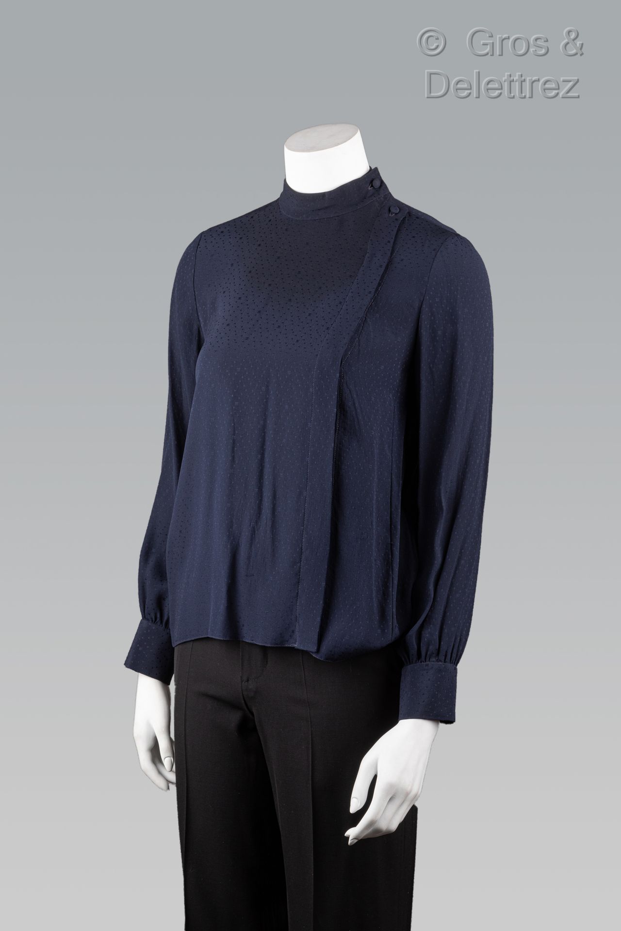 Null 香奈儿专卖店

深蓝色真丝绉绸衬衫，有圆点和锉刀图案，小立领，衣襟下有不对称单扣，长袖。黑色标签，白色图案。