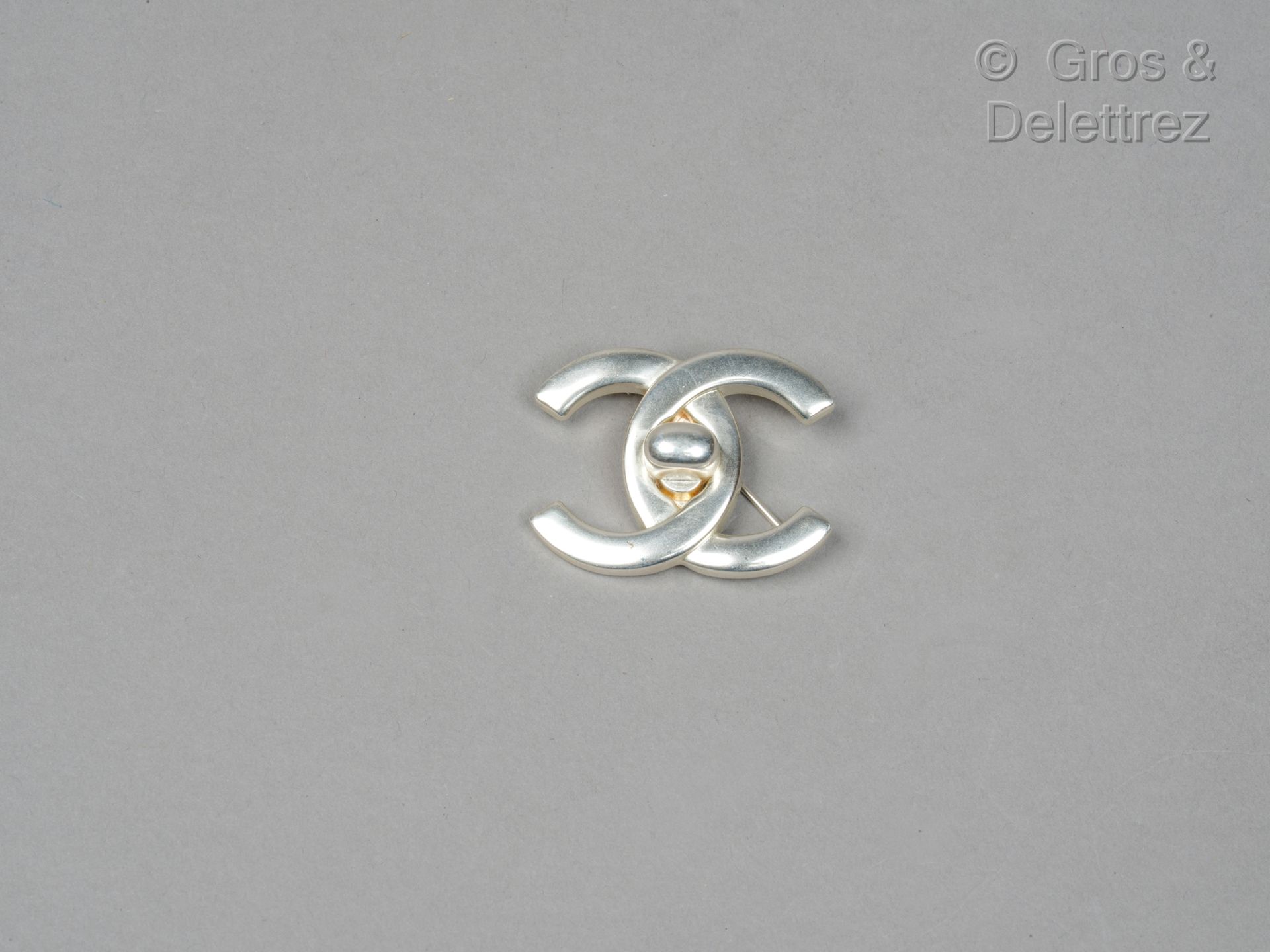 Null 卡尔-拉格斐的香奈儿

1996年春夏高级成衣系列

银色金属 "amati "胸针，代表 "Classique "手袋的扣子。盘上有签名。高度：2.&hellip;