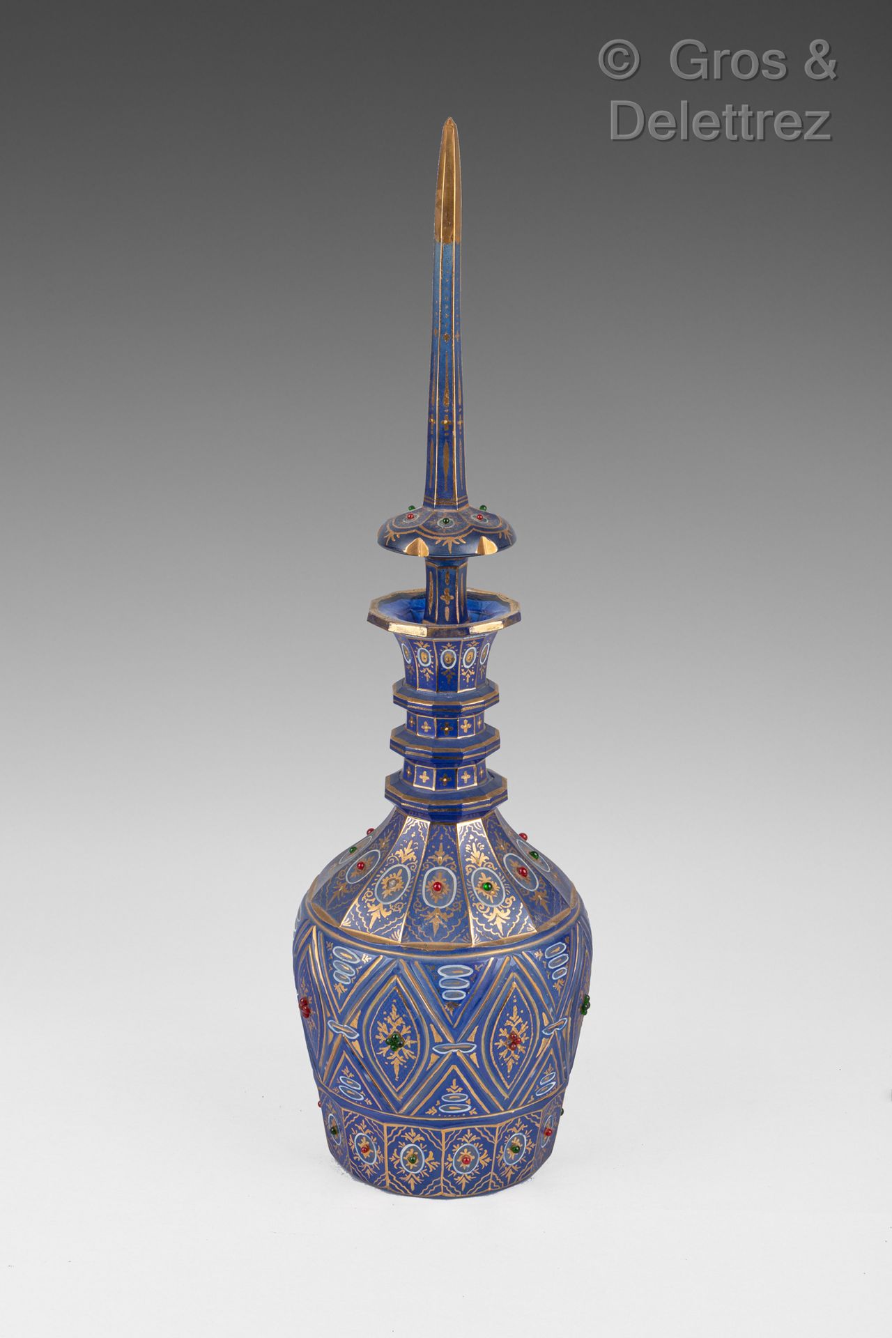 Null 面向伊朗市场的波西米亚人。

蓝色玻璃瓶，装饰有雕刻的几何和花卉图案，并以金色和红色及绿色凸圆形宝石加强。

约1880年

高度：58厘米。缺少的小&hellip;