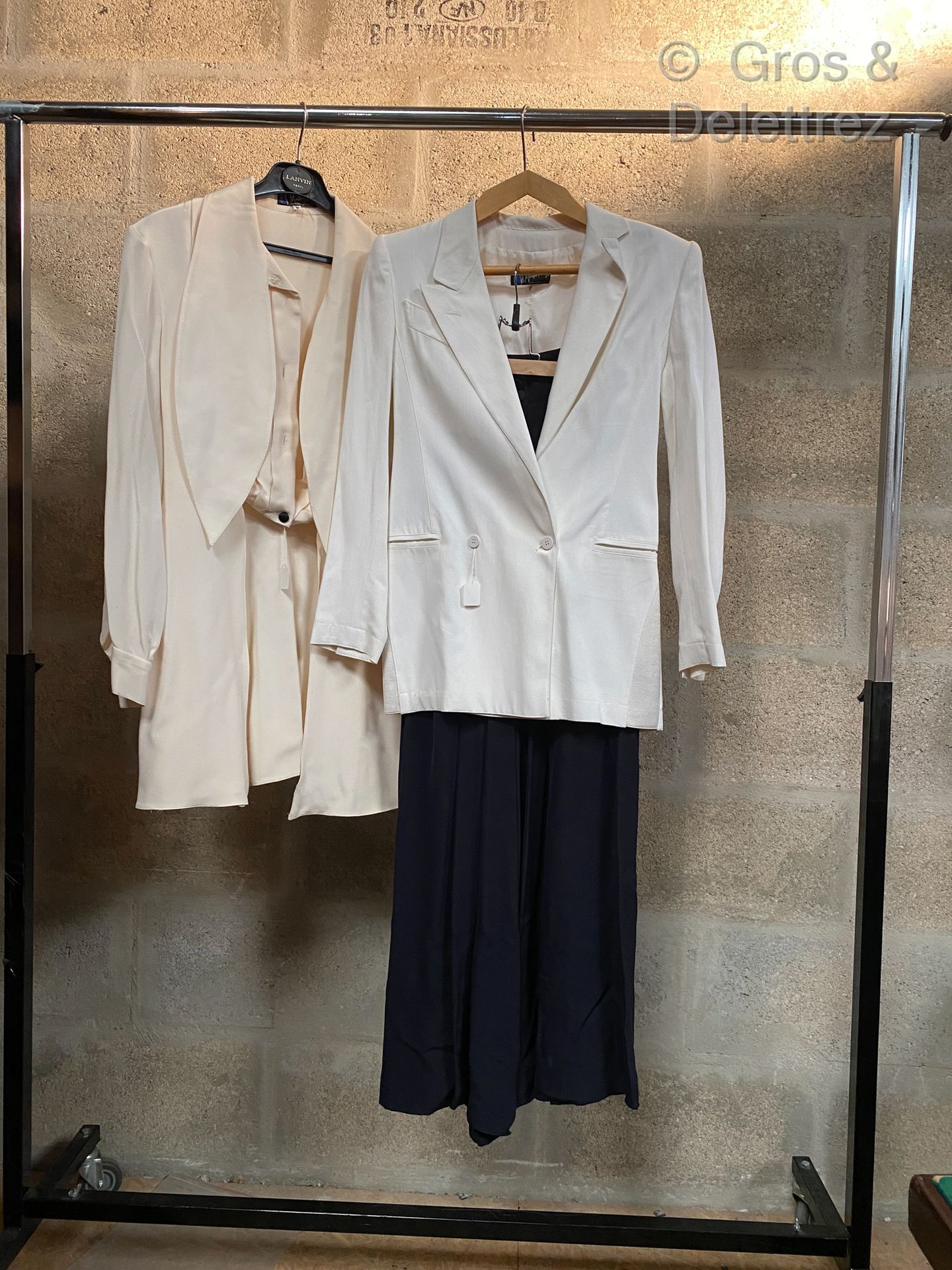 Null MONTANA套装包括一件白色棉质双排扣西装外套，一条深蓝色百褶裙和一件象牙色丝绸外套。