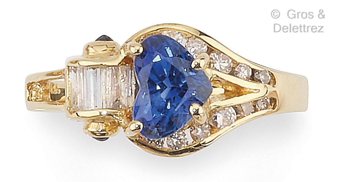 Null 一枚黄金戒指，镶嵌着一颗心形切割蓝宝石，周围环绕着明亮式切割钻石，并以镶嵌长方形钻石的卷轴为亮点。手指大小：50½。毛重：3.2克。