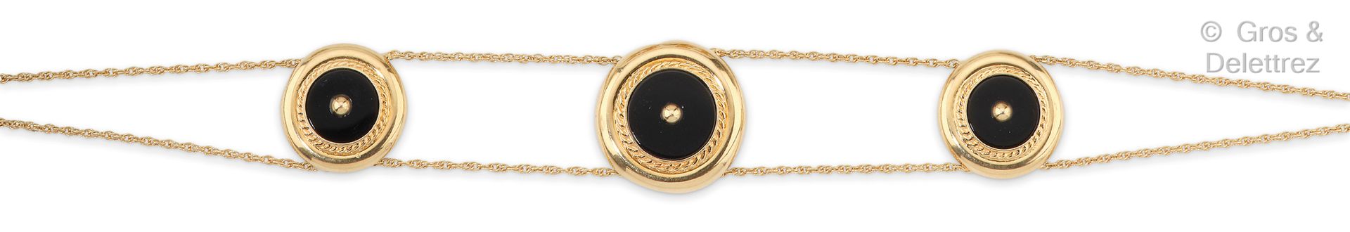 Null 黄金手镯，由两条链子组成，链子上的圆形图案在扭曲的框架中镶嵌着黑玛瑙板，顶部有一颗金珍珠。长度：18.5厘米。毛重：6.5克