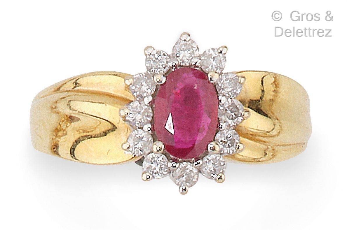 Null 一枚黄金 "花 "戒指，在明亮式切割钻石的包围中镶嵌着一颗椭圆形红宝石。手指大小：50½。毛重：4.5克。
