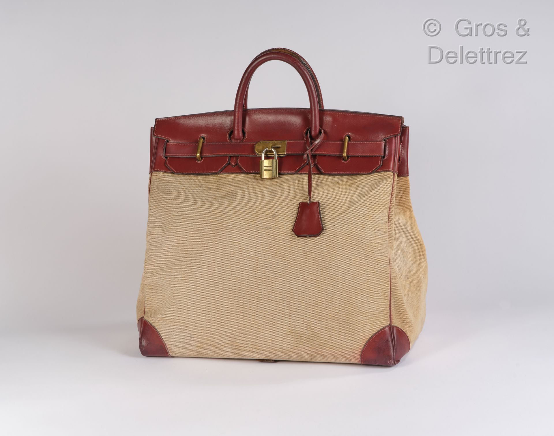 HERMES Paris 旅行袋 "Haut à Courroies" 45厘米，米色斑驳帆布H和红色盒子H，镀金黄铜扣件和搭扣，双手柄，钥匙在铃铛下，挂锁。(&hellip;