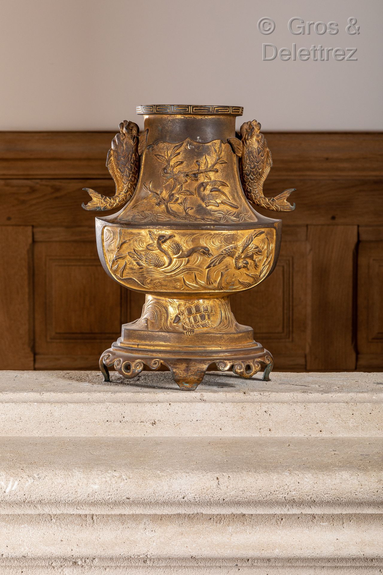 JAPON 一件镀金的青铜花瓶，轻浮地装饰着海龟、云彩背景上的龙、鹅和鸟，侧面的把手是海豚的形状。

19世纪

高：35厘米