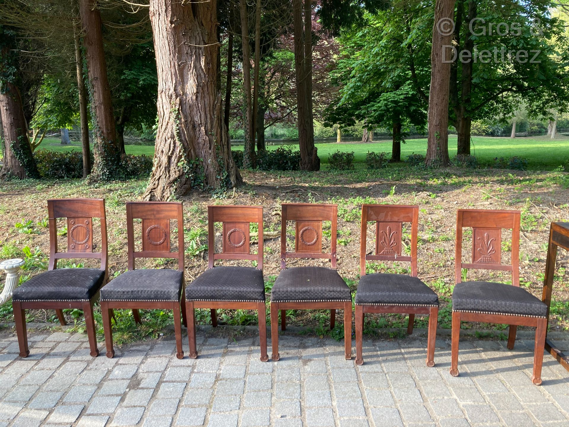 Null 六把桃花心木和桃花心木饰面的餐椅，笔直的镂空椅背上装饰着棕榈树、月桂花环和月桂花环与叶状飞鸟。

19世纪初

84 x 44 厘米。事故和修复