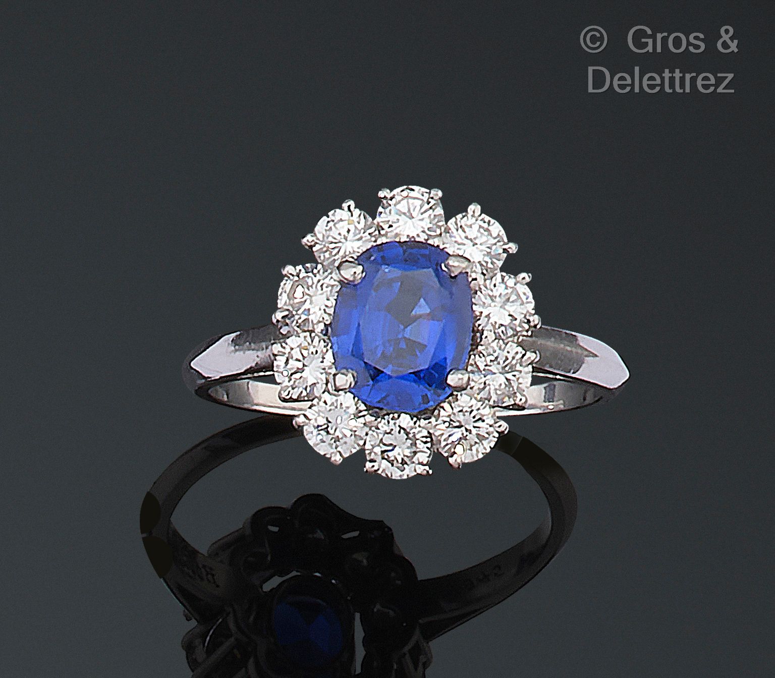 BOUCHERON 白金 "花 "戒指，在一圈明亮式切割钻石中镶嵌一颗蓝宝石。签名的Boucheron。蓝宝石尺寸：8.5 x 6.9 x 4.4毫米。 原产地&hellip;