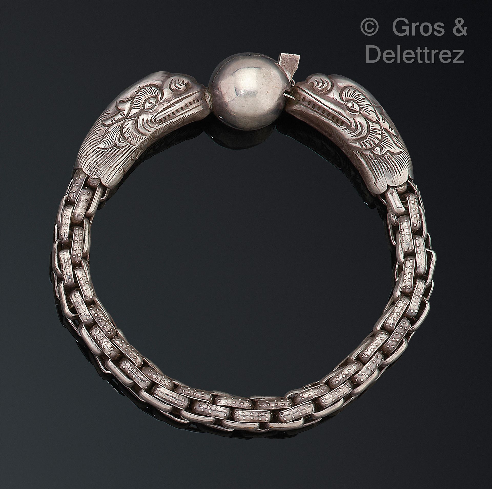 Null 灵活的银手镯，由花式链节组成，以两个奇美拉的头颅为结尾，并以一颗珍珠作为扣子。手腕尺寸：16.5厘米。D. 28克。