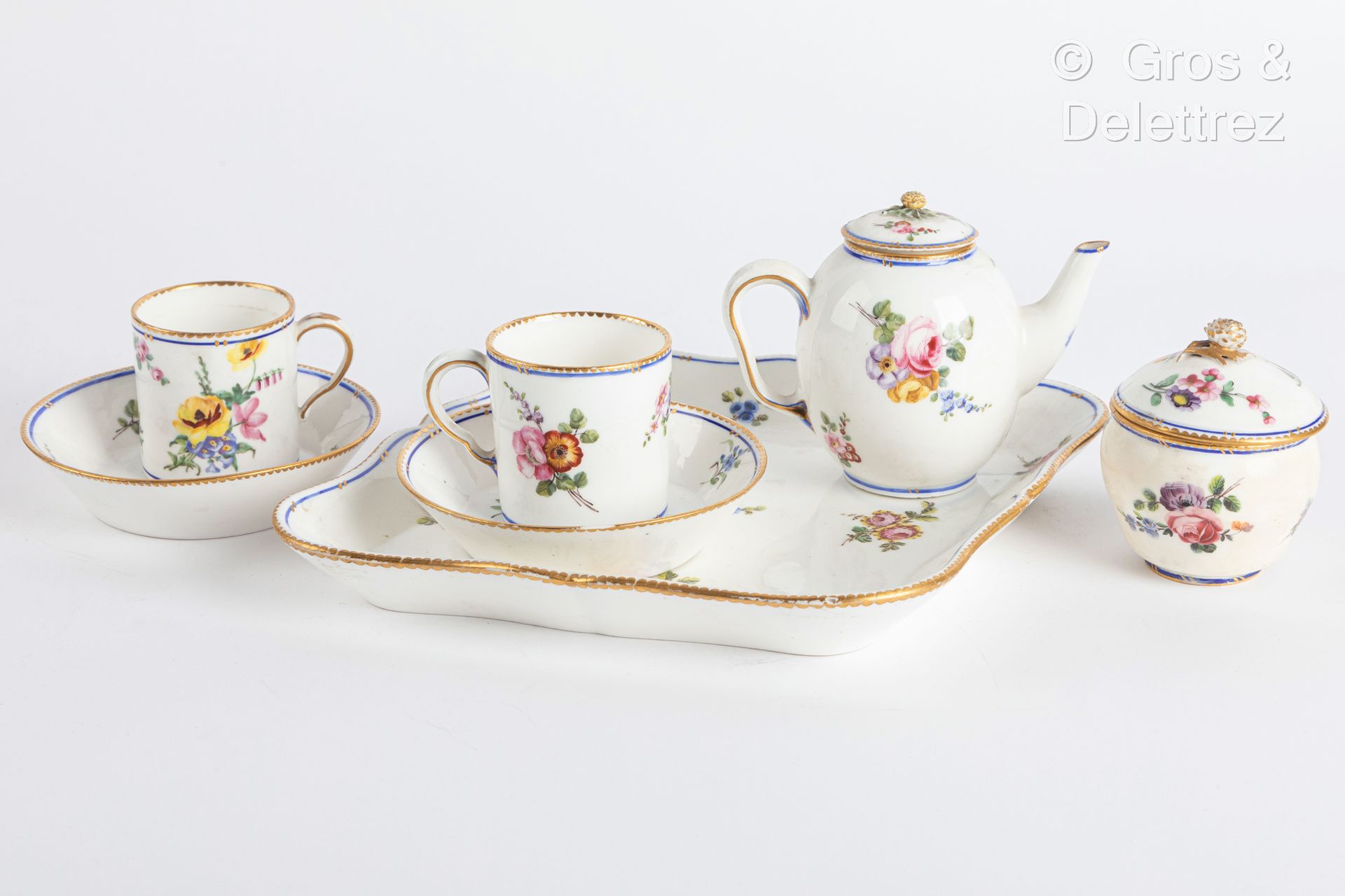 Null Sèvres

软瓷复合菱形午宴，包括一个菱形托盘，一个有盖的卡拉布里亚茶壶，一个赫伯特糖罐，两个升杯及其碟子，上面有蓝色和金色的花束和网状的多色装饰&hellip;
