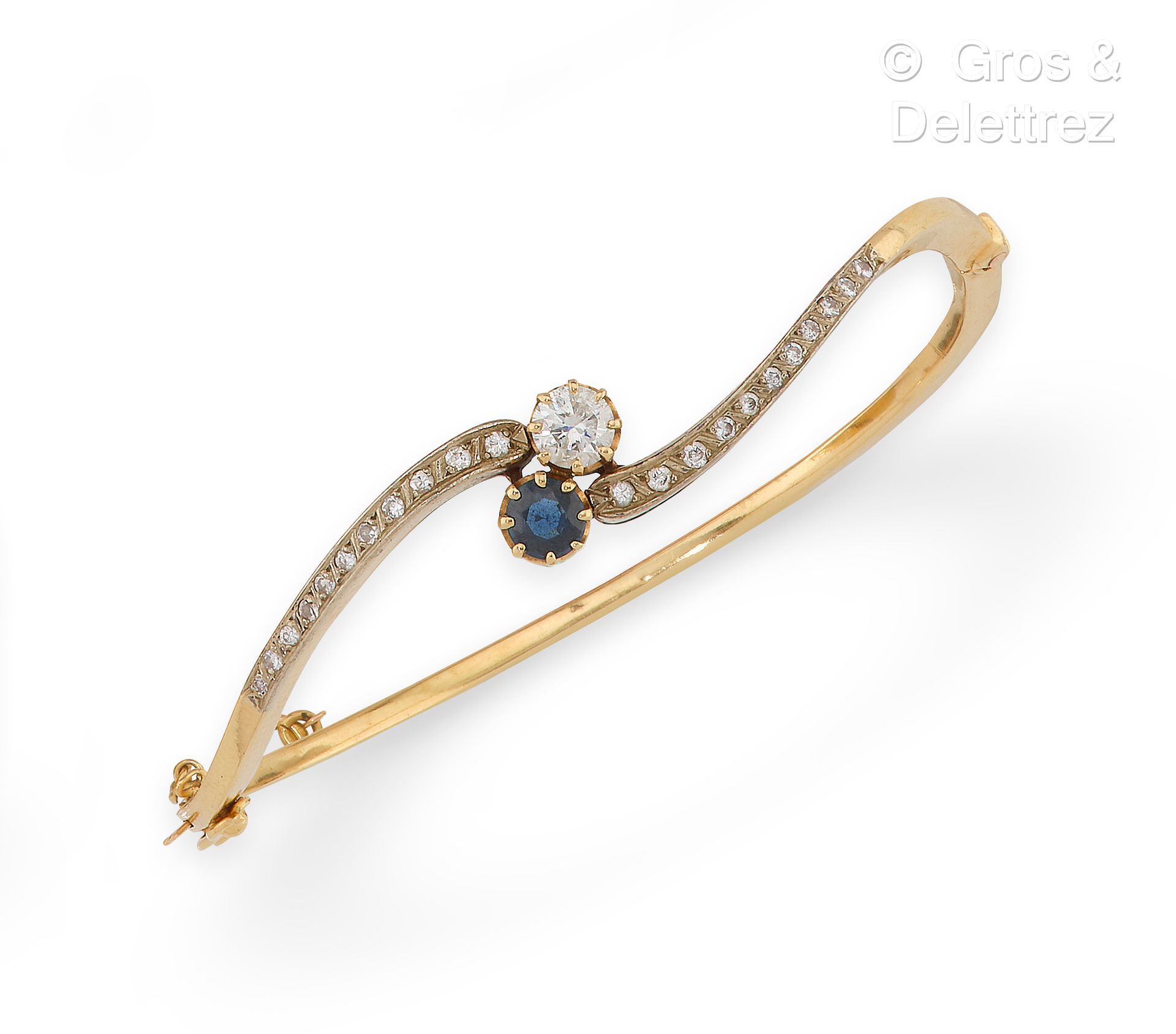 Null 黄金 "Opening band "手镯，由镶嵌有蓝宝石和明亮型切割钻石的卷轴和较小钻石组成。手腕尺寸：18厘米。毛重：19.2克。