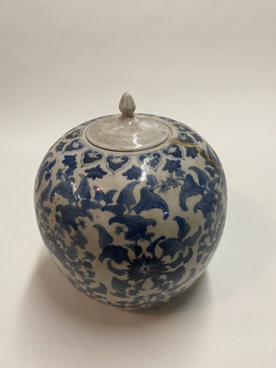 Null 
(E) 中国。瓷盖壶，饰以蓝色的叶子。

现代工作

高度：26厘米
