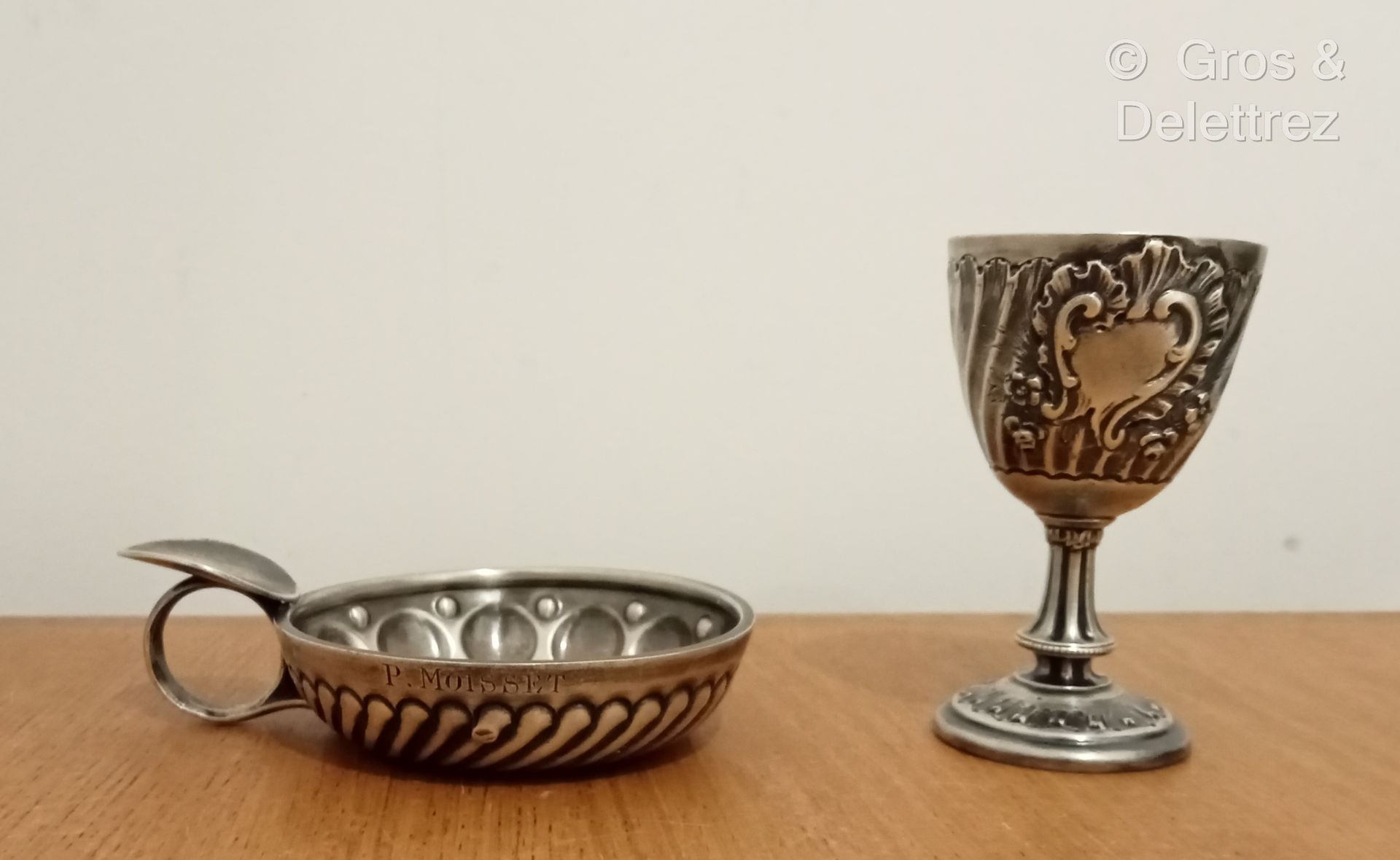 Null (E) 一件银质拍品，包括一个带底座的鸡蛋杯，上面装饰着扭曲的肋骨背景上的罗盖尔图案，以及一个带有小圆点和杯状物的品酒器。

Minerve标志 - &hellip;