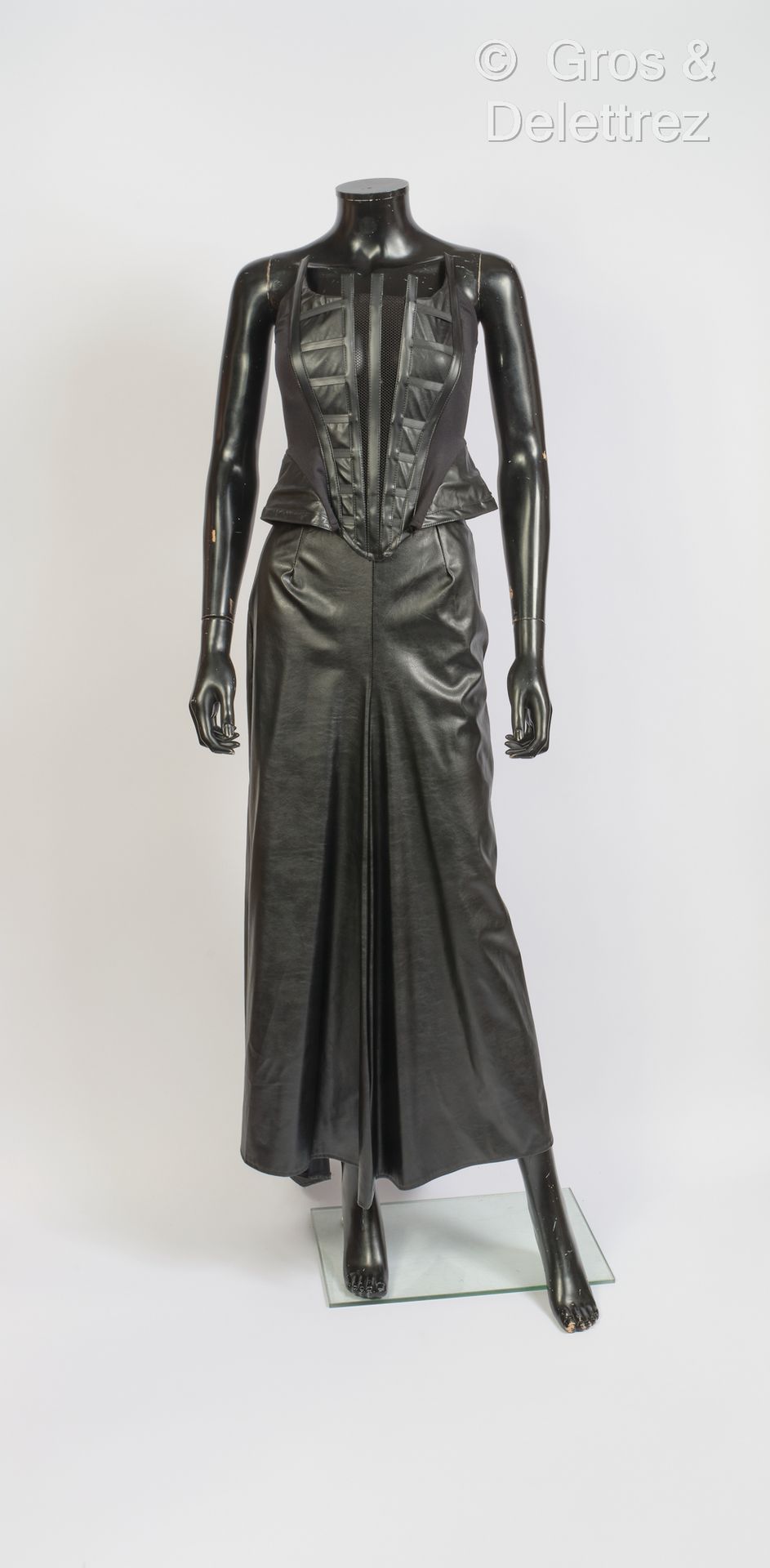 SDL 黑色乙烯基套装，包括带鲸鱼骨和鱼网的紧身胸衣和长喇叭裙。