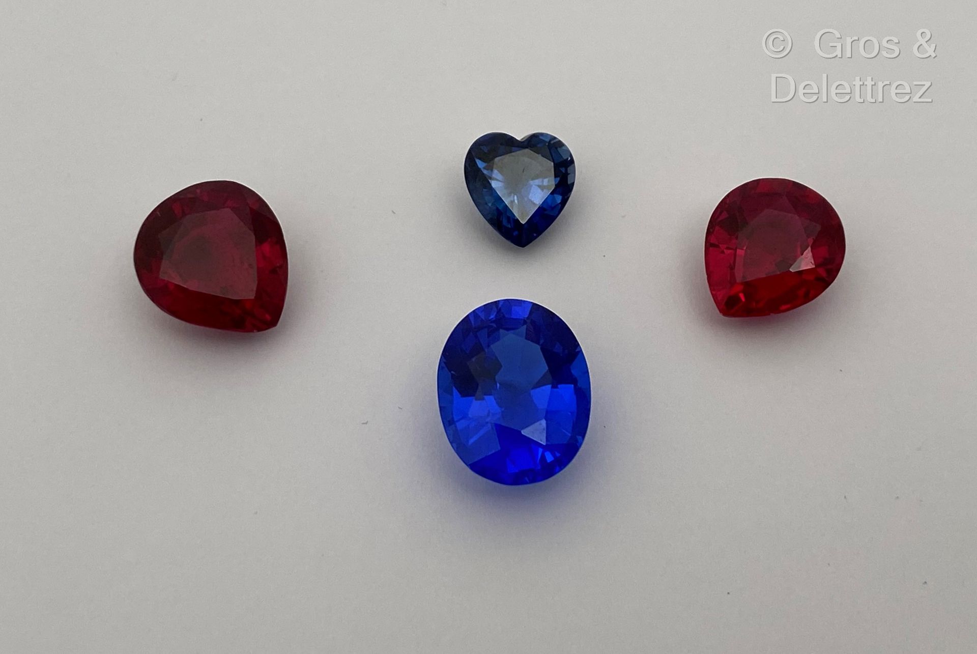 Null 一批四颗蓝色和红色的合成宝石，有椭圆、梨形和心形。
