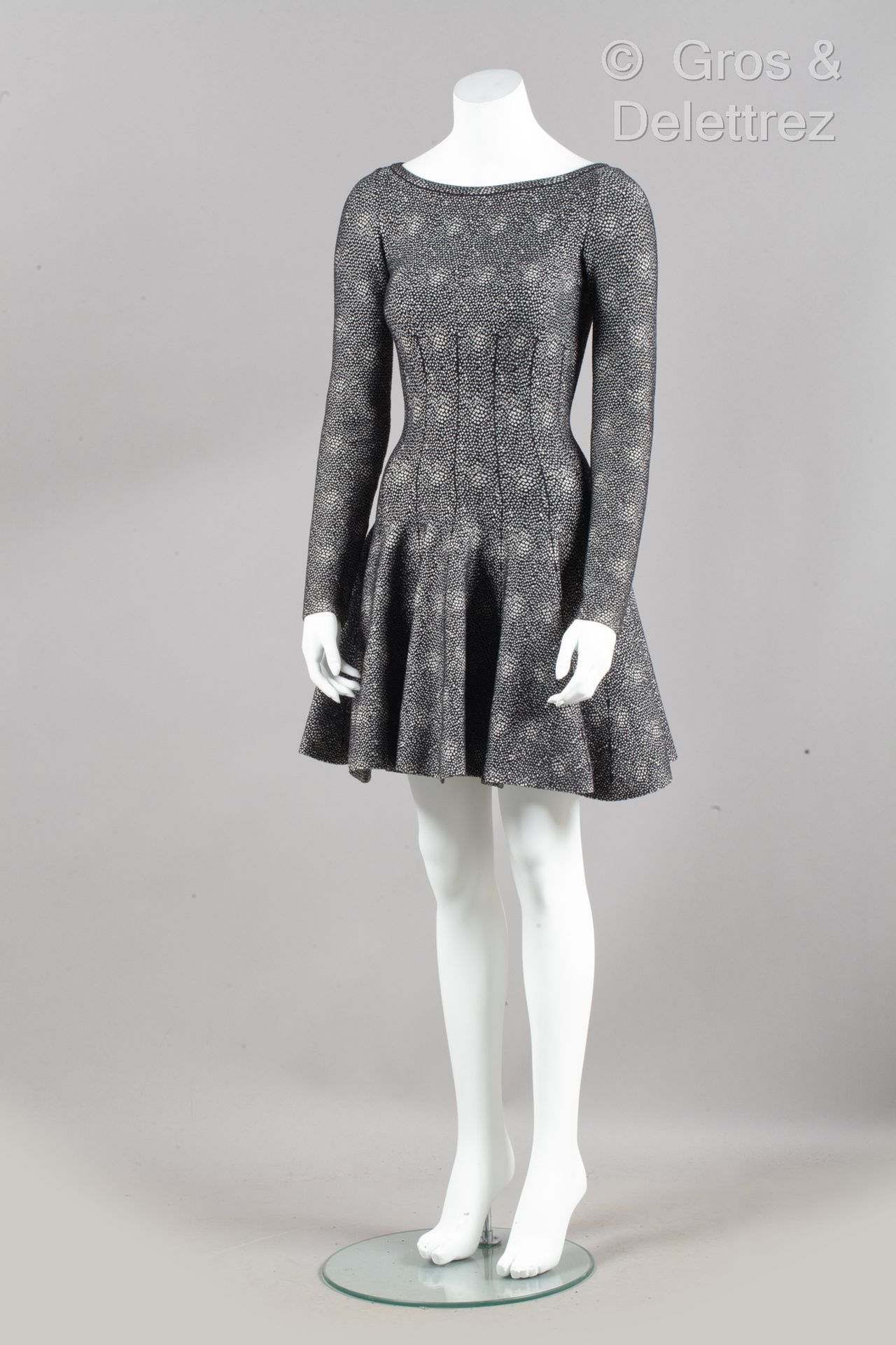 ALAÏA 黑白相间的斑纹羊毛短裙，圆领，长袖，腰部以下为喇叭裙（缺爪子）。