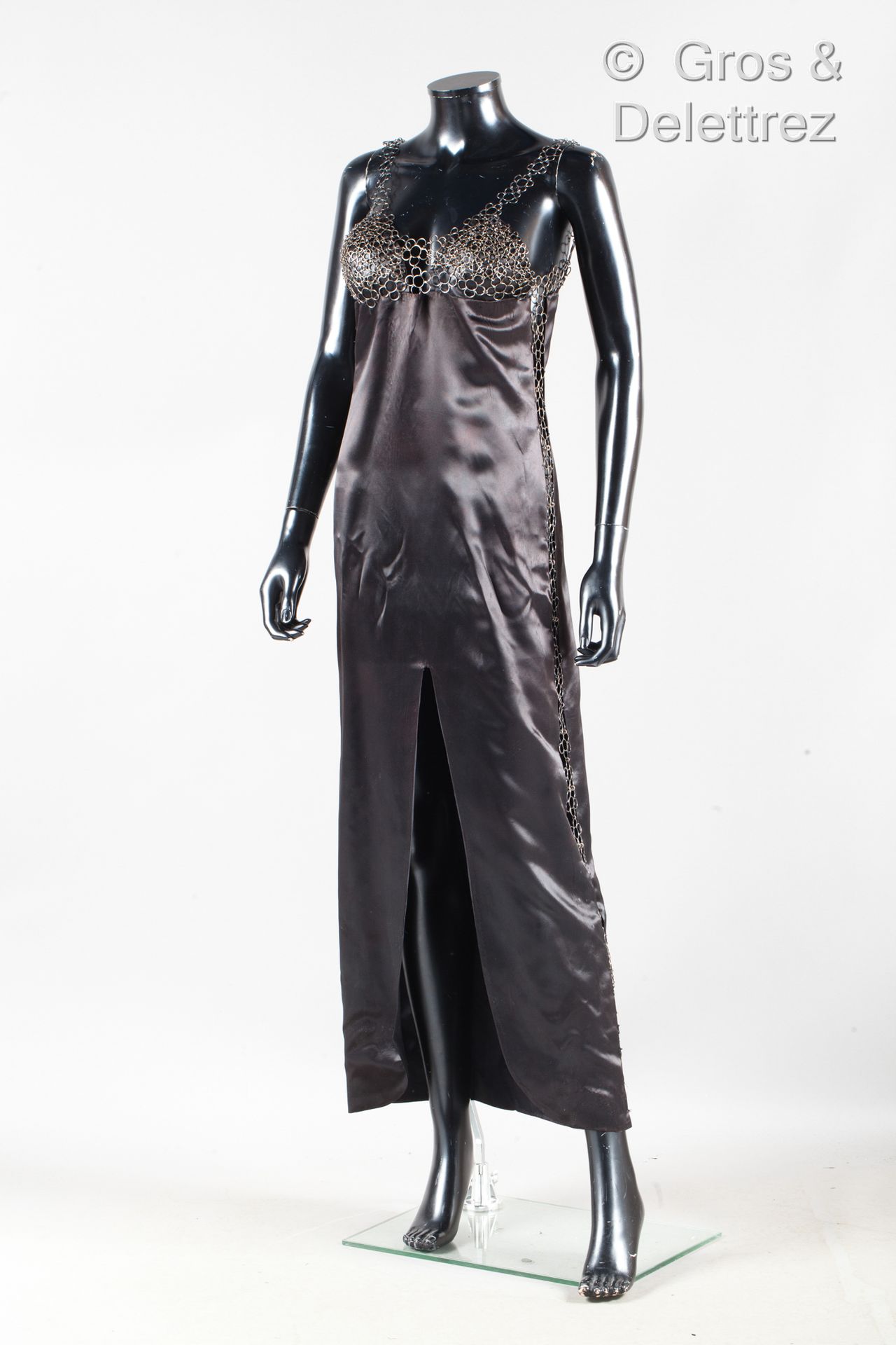 Paco RABANNE 黑色缎面长裙，胸部覆盖着清漆金属菊花图案，继续用两条协调的带子，提醒侧边开口，前面有缝隙（缺爪，事故）。
