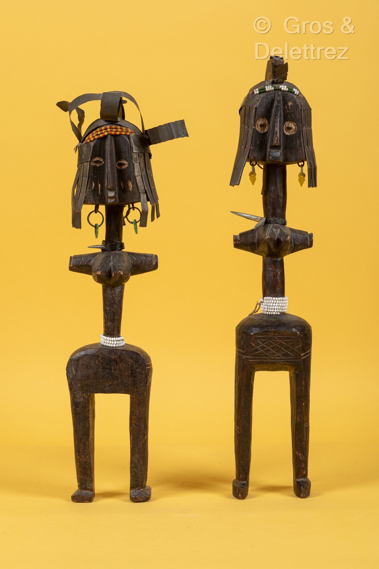 Style Bagirmi, TCHAD 一对大型铜化木制人物，代表两位带着金属头饰和小饰品的女性。
高度：55.5和50.5厘米。