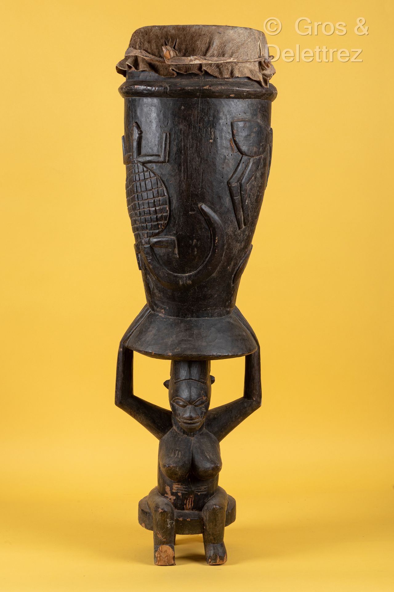 Style Senoufo, COTE D’IVOIRE 大木鼓浮雕乌龟和鸟，一个坐着的女性形象支撑着鼓身。皮顶。
高度：110厘米。