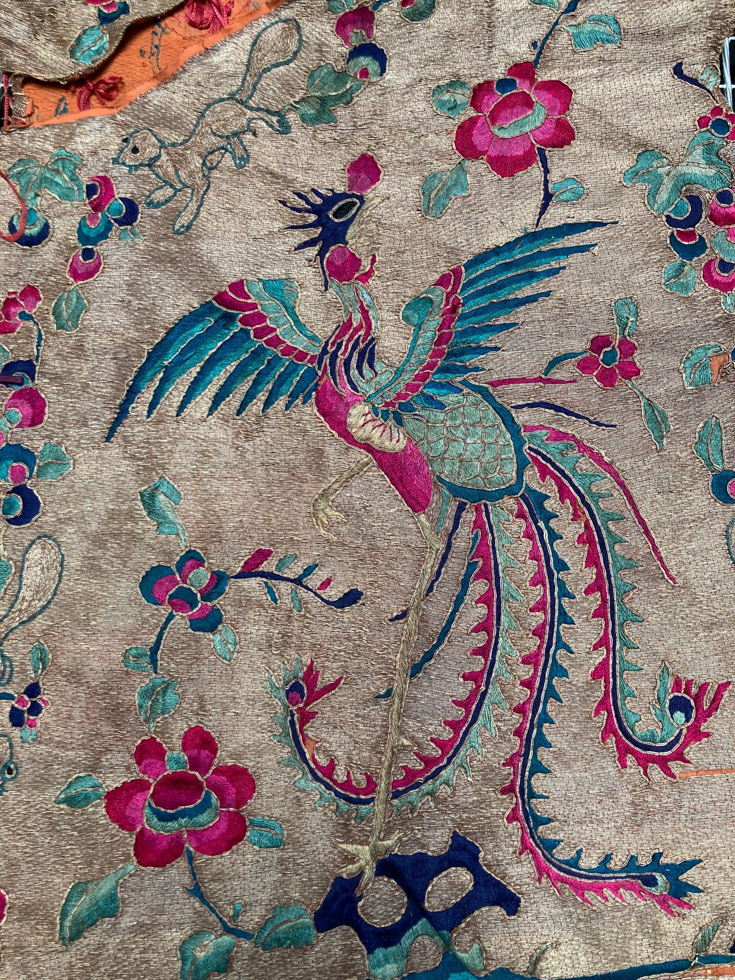 Null 中国北部-西部，19世纪
粉色、蓝色和绿色的羊毛和金丝线的衣服，装饰有凤凰和藤枝间的睡鼠。 
H.102 cm - W. 118 cm 
(领口和边缘&hellip;