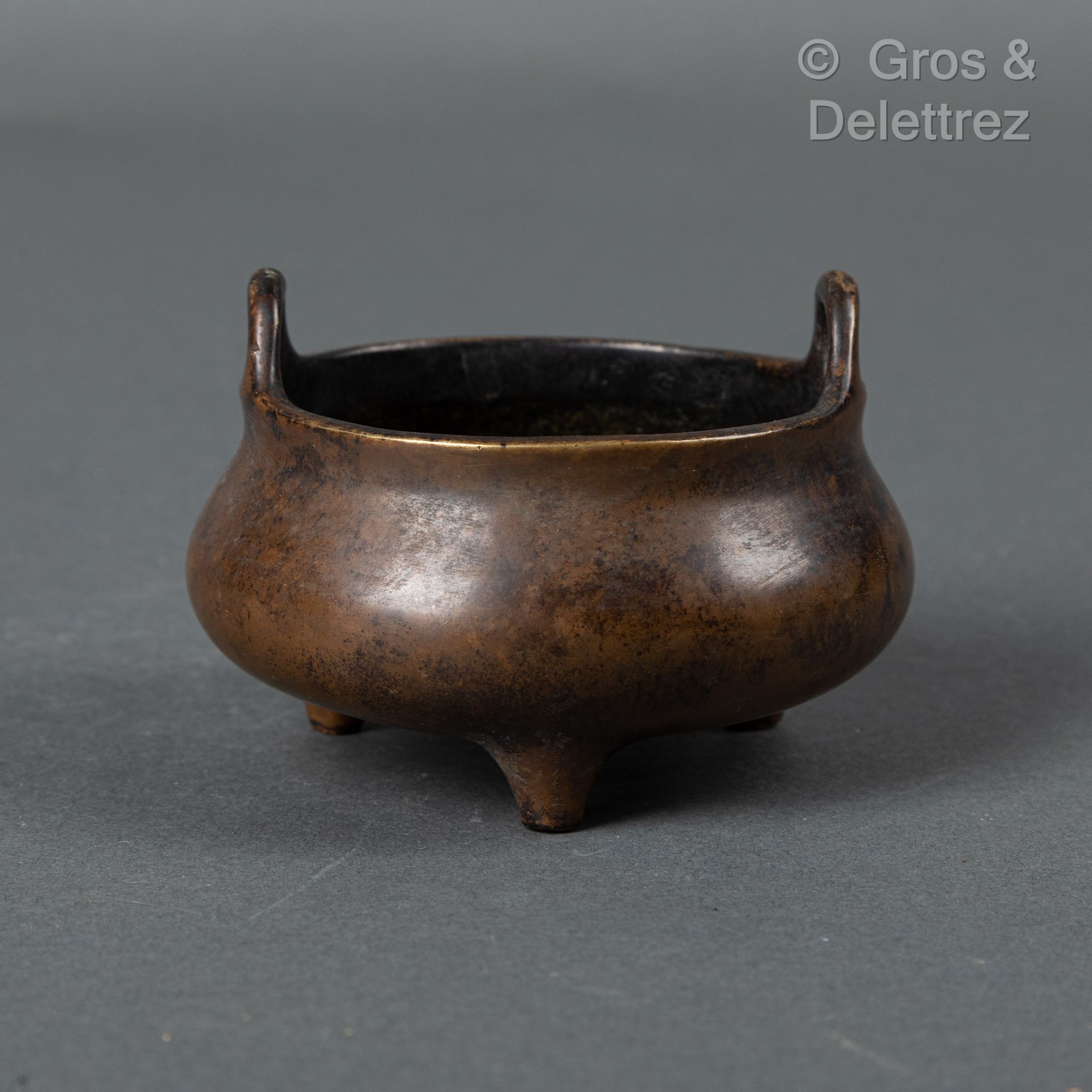 Null 中国，19世纪
小型鼎形铜香炉，有两个弯曲的把手。底部有伪装的宣德款。 
直径：10厘米