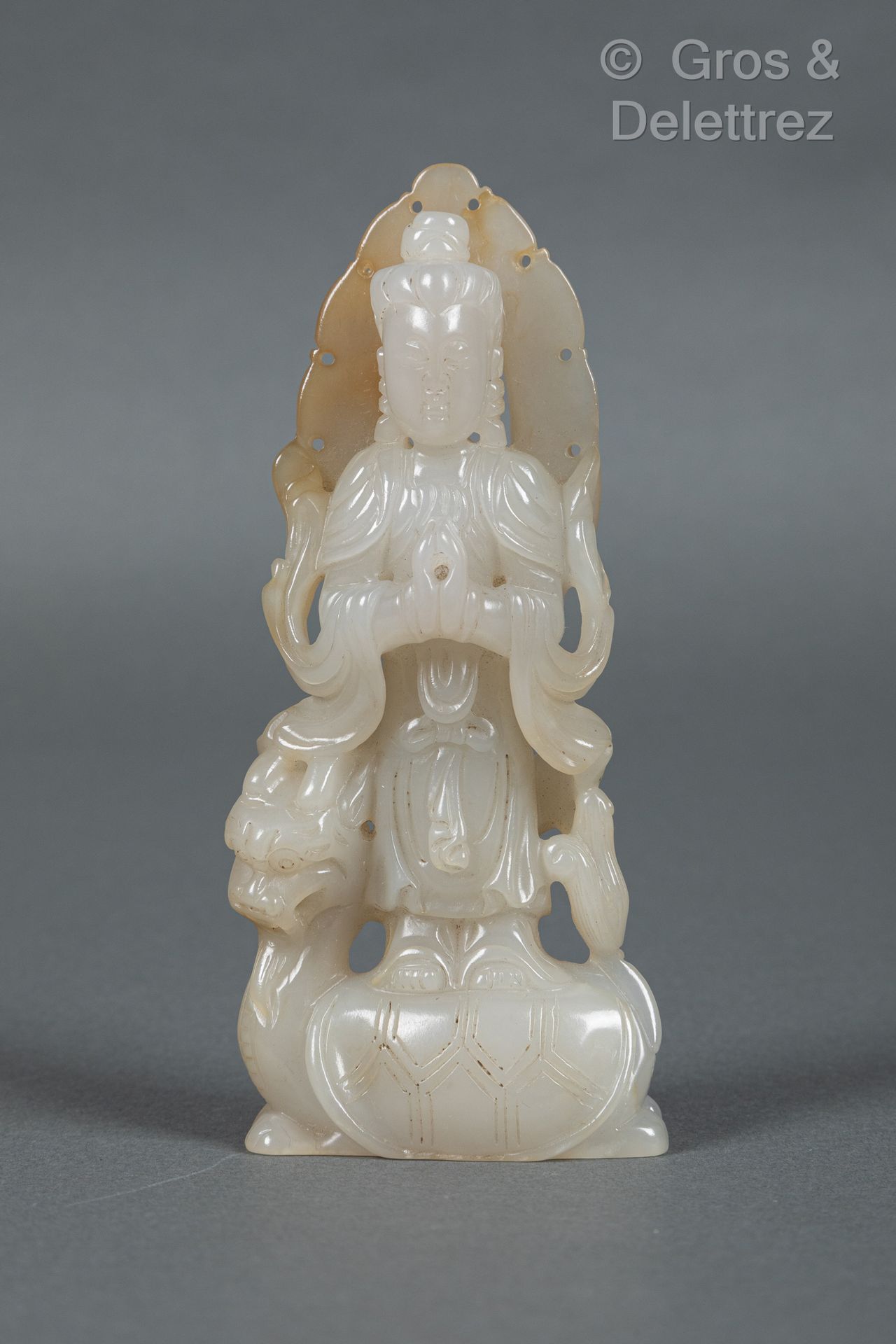 Null 中国，20世纪
青花瓷玉器上有轻微的铁锈纹，表现观音菩萨站在莲花上，双手合十，靠在曼陀罗上。 
H.14.3厘米