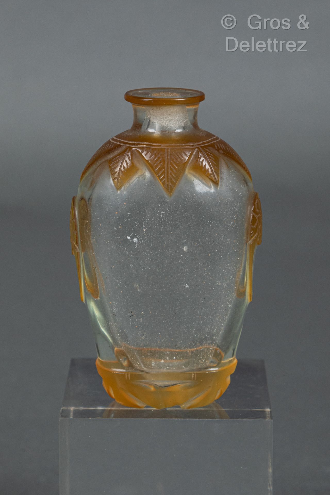 Null 中国，19世纪末
一件半透明和橙色套料的玻璃鼻烟壶，装饰有叶子和面具形成的把手。