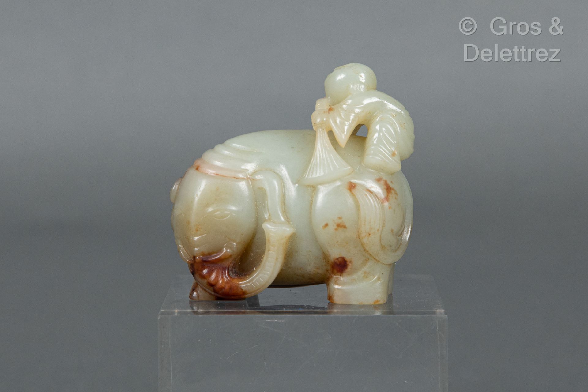 Null 中国，20世纪 
一件青瓷玉器主题，有轻微的铁锈纹，表现大象在其背上的人物帮助下梳理自己。 
H.5.3厘米