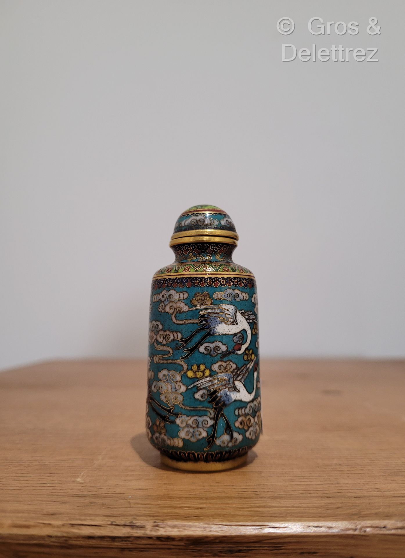 Null 中国，20世纪 
铜胎掐丝珐琅的鼻烟壶，蓝色背景上有云中鹤的多色装饰。底部刻有乾隆年款。
H.7厘米
