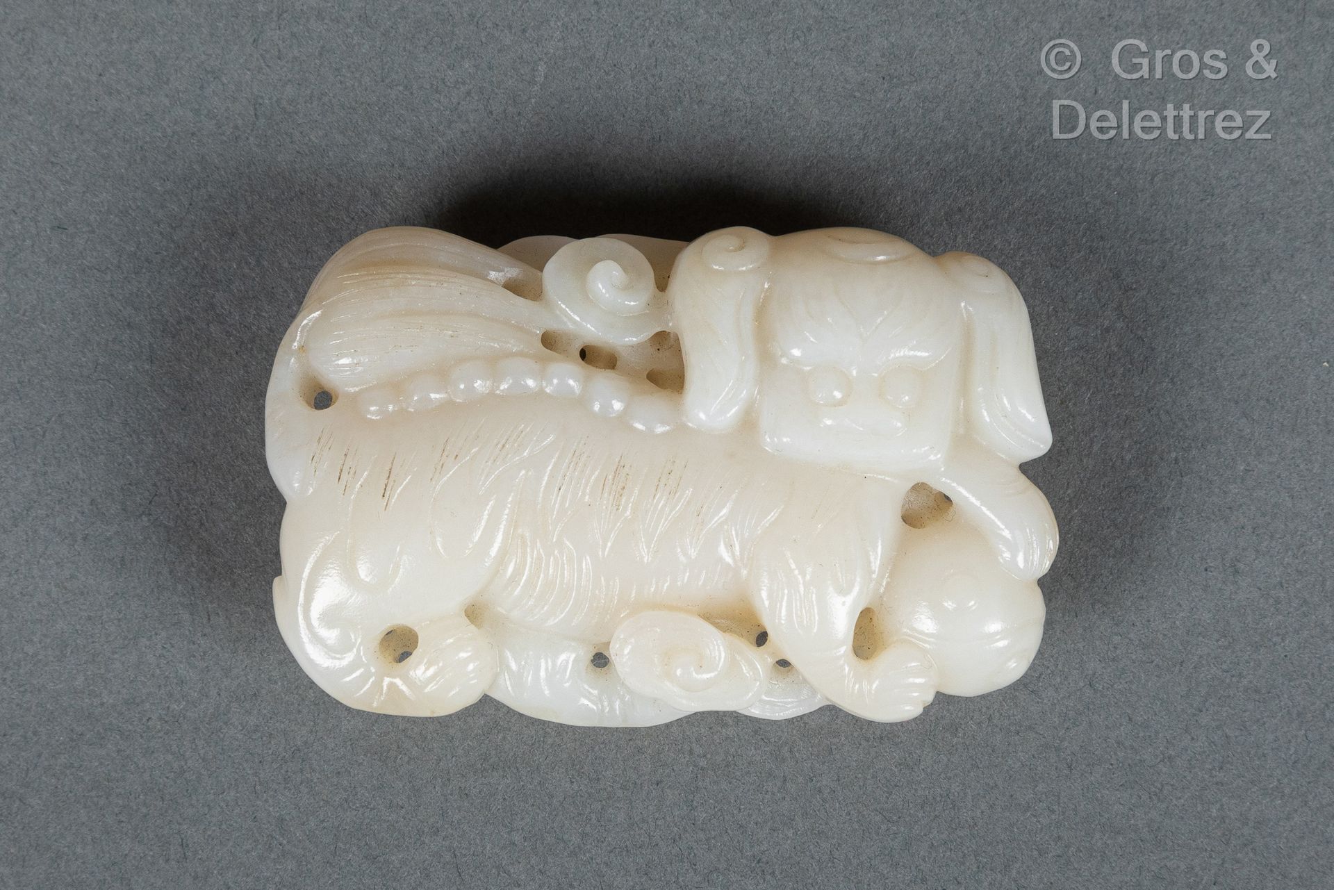 Null China, circa 1900
White jade belt buckle, representing a fô dog. 
L. 7.4 cm